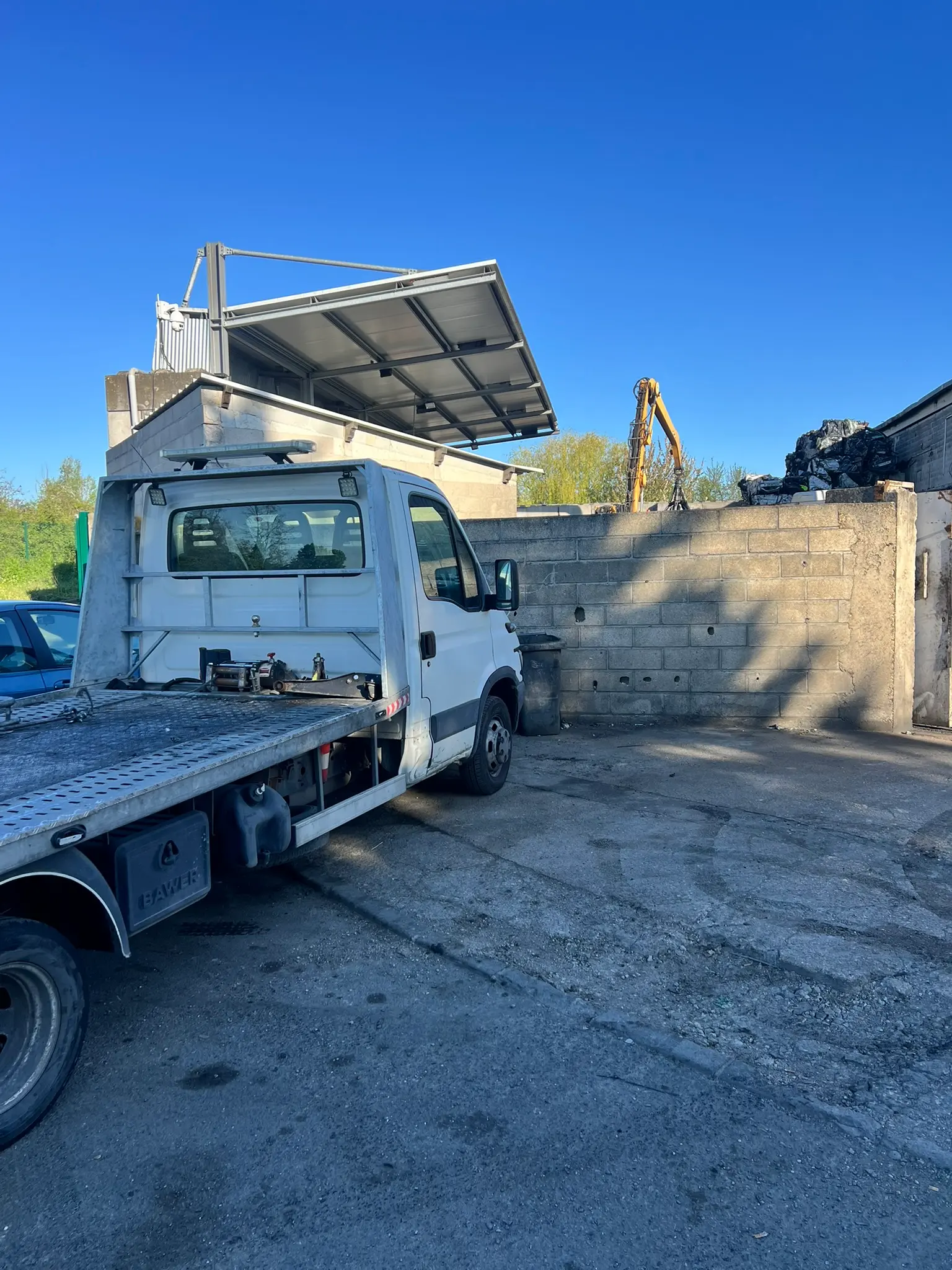 Enlèvement d'épave en Île-de-France — camion plateau AMIL AUTO livrant un véhicule au centre VHU agréé